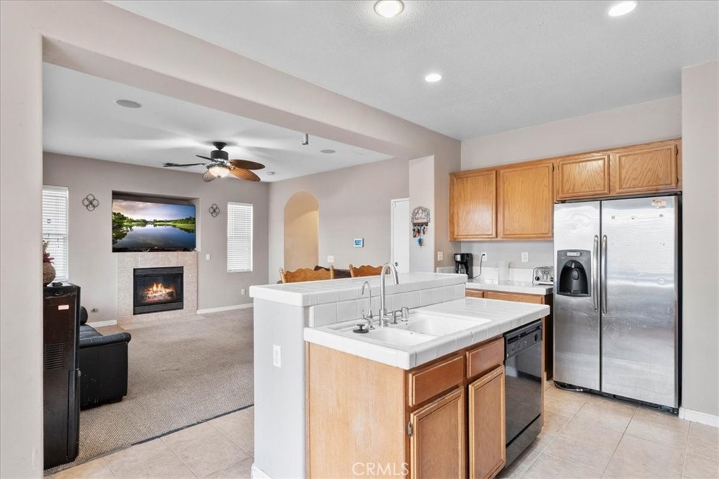 1474 Albillo Loop Perris, CA 92571 - Photo 13 of 35 a kitchen with kitchen island a sink appliances and cabinets