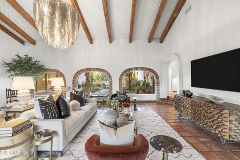 a living room with furniture a flat screen tv and a large window