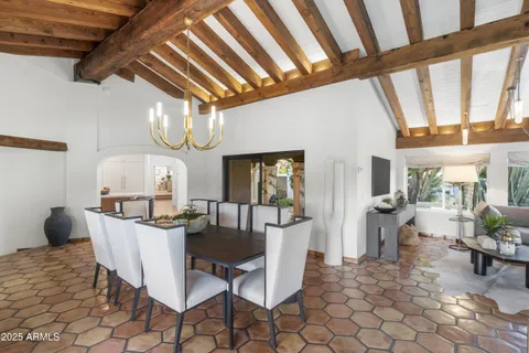 a living room with furniture a flat screen tv and a wall painting