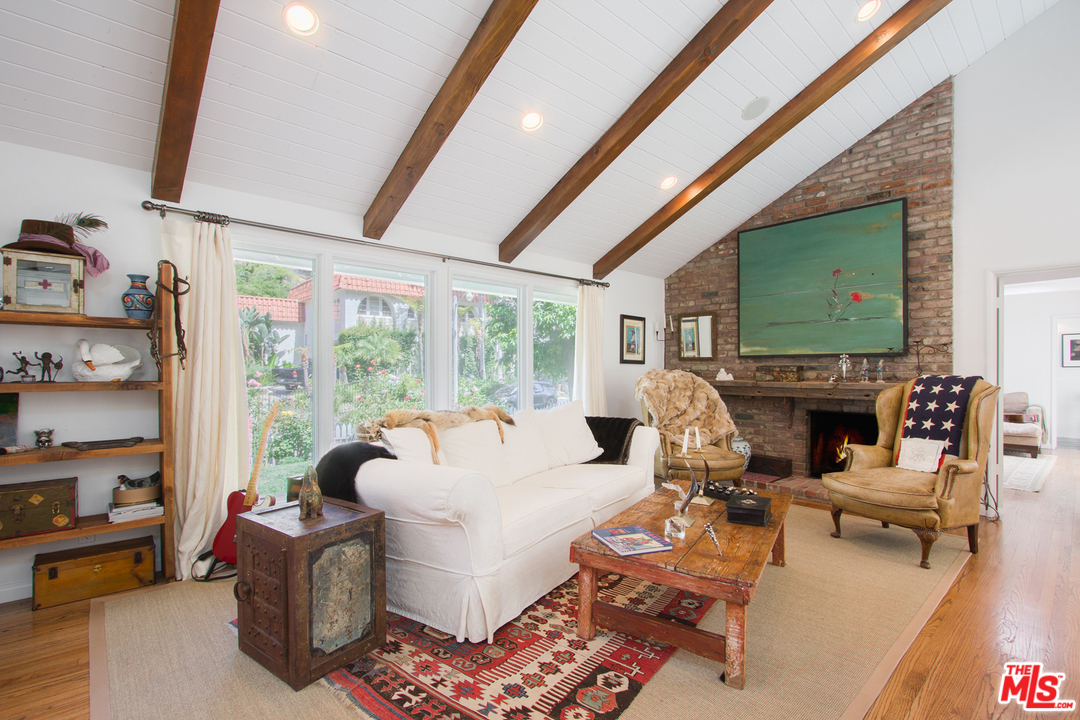 1538 Roscomare Road Los Angeles, CA 90077 - Photo 2 of 26 a living room with furniture a fireplace and a flat screen tv