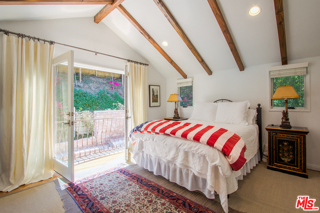 1538 Roscomare Road Los Angeles, CA 90077 - Photo 15 of 26 a bedroom with a bed a mirror and a window
