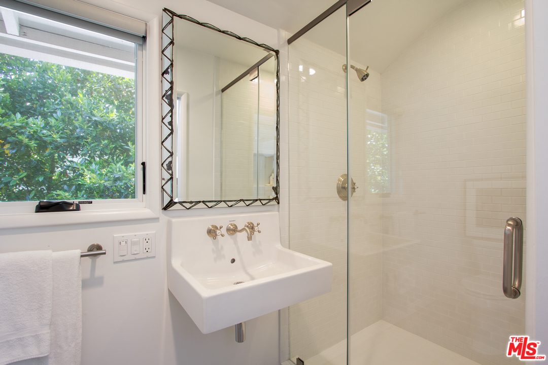 1538 Roscomare Road Los Angeles, CA 90077 - Photo 19 of 26 a bathroom with a sink a mirror and a shower