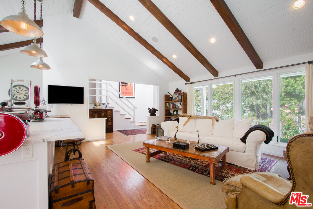 1538 Roscomare Road Los Angeles, CA 90077 - Photo 3 of 26 a living room with furniture a flat screen tv and a floor to ceiling window