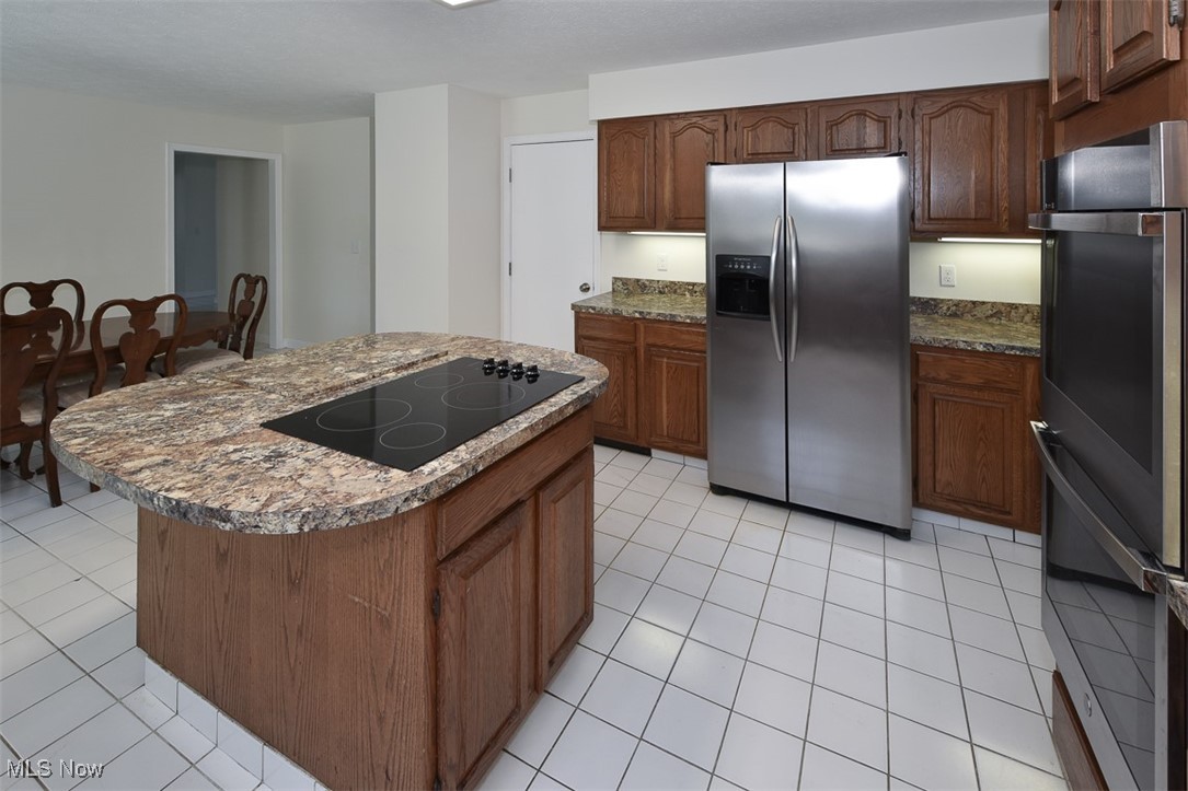 30776 Cedar Road Cleveland, OH 44124 - Photo 8 of 41 Kitchen with stainless steel appliances, light tile patterned flooring, and a kitchen island
