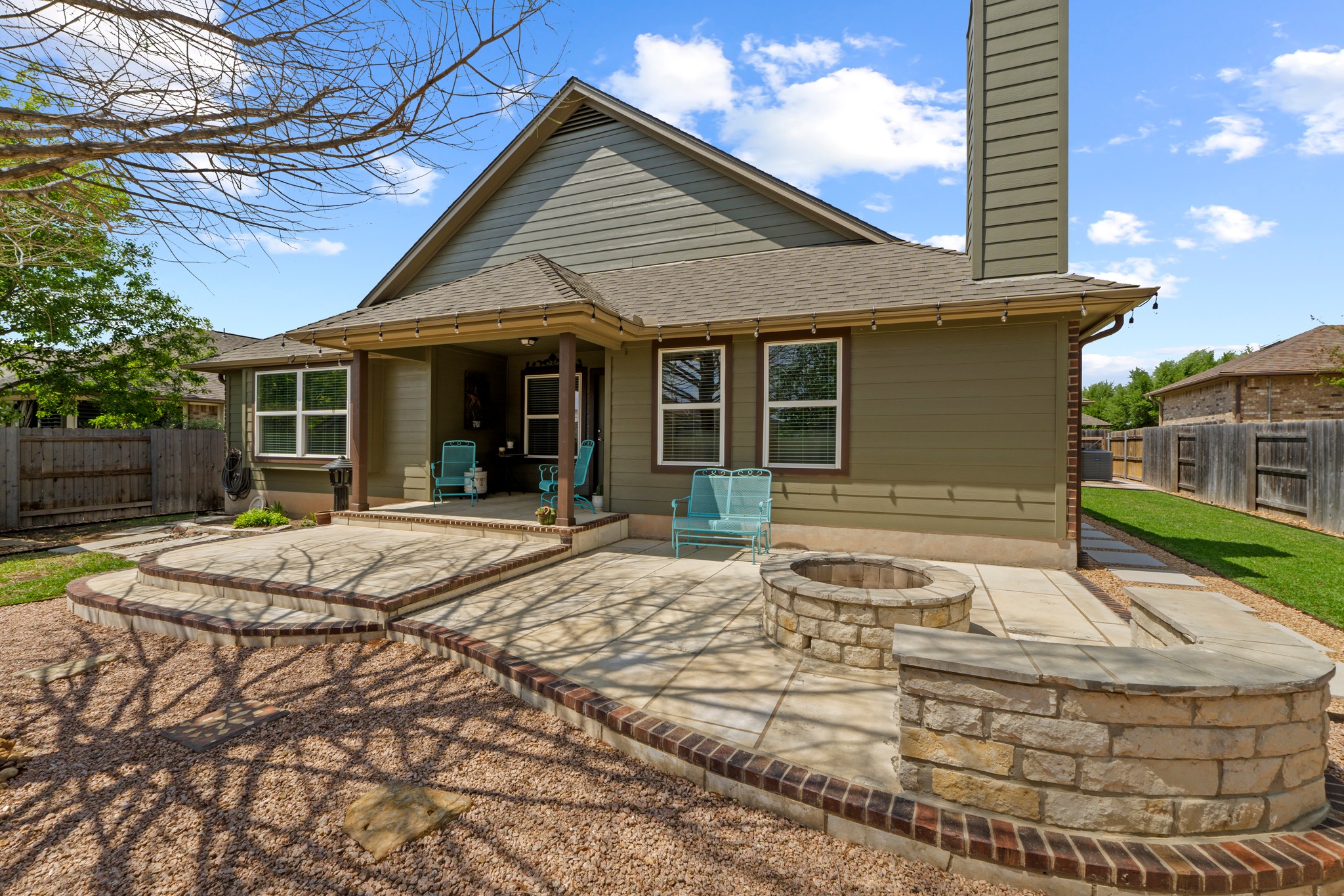 20525 Jackies Ranch Boulevard Pflugerville, TX 78660 - Photo 26 of 27 Back of house featuring a fenced backyard, a patio area, a shingled roof, a fire pit, and a chimney