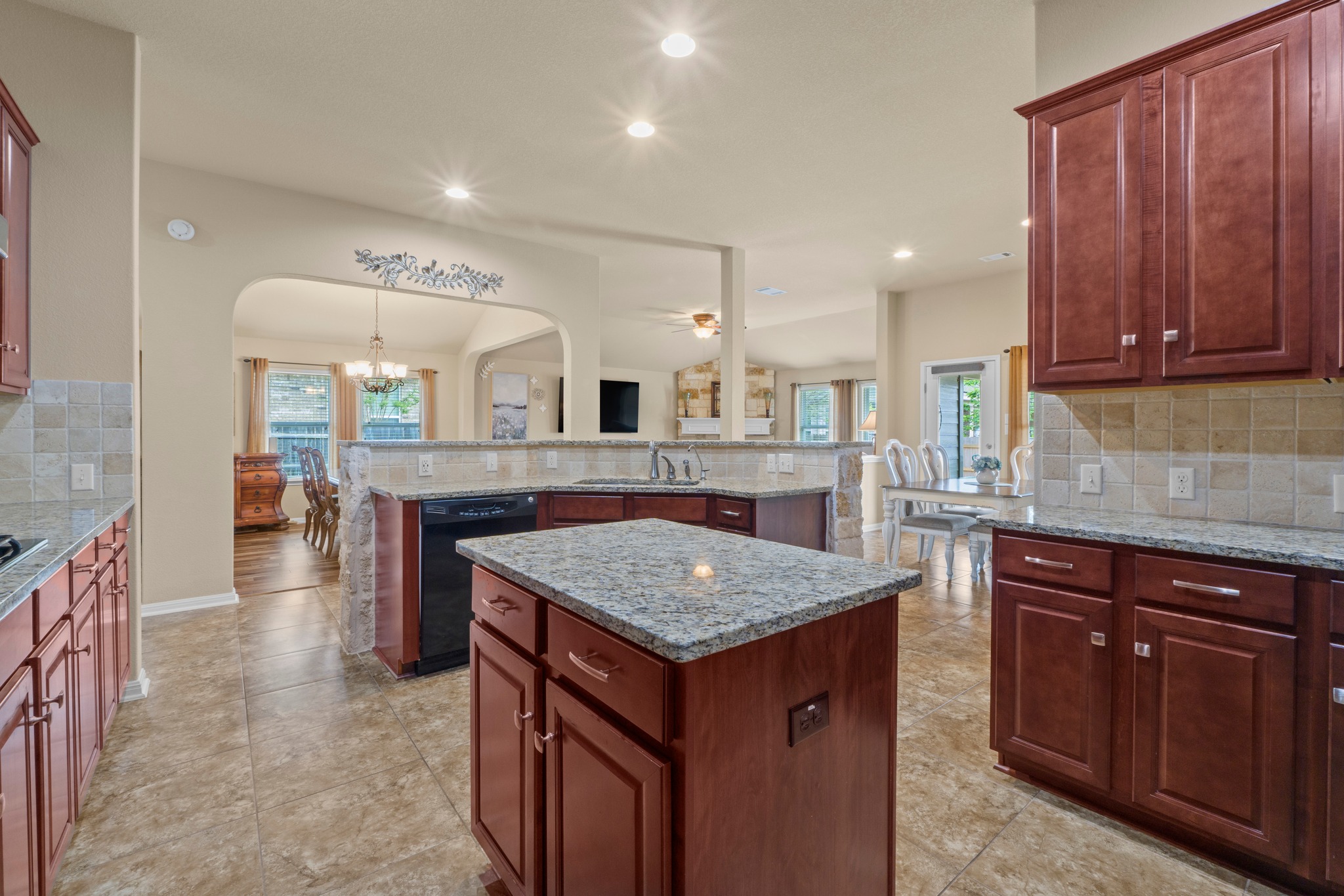 20525 Jackies Ranch Boulevard Pflugerville, TX 78660 - Photo 8 of 27 Kitchen featuring tasteful backsplash, light granite counters, dishwasher, and center island with storage