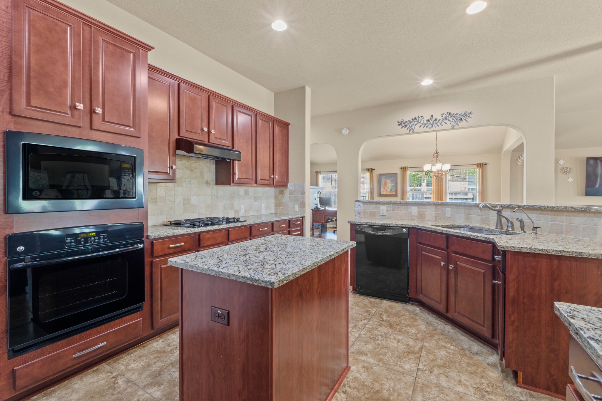 20525 Jackies Ranch Boulevard Pflugerville, TX 78660 - Photo 9 of 27 Kitchen featuring built in appliances, a center island, decorative backsplash