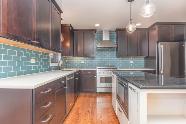 a kitchen with stainless steel appliances granite countertop a sink stove and refrigerator