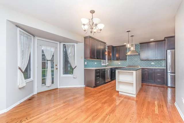 a large kitchen with granite countertop a large counter top space appliances and cabinets