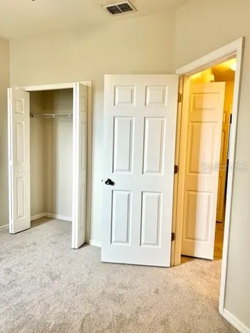 an empty room with a ceiling fan and window