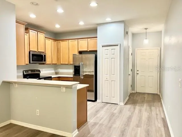 a kitchen with a refrigerator a stove top oven and white cabinets