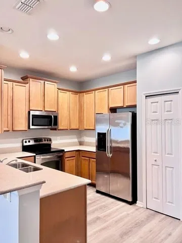 a kitchen with stainless steel appliances granite countertop a stove a sink and a refrigerator