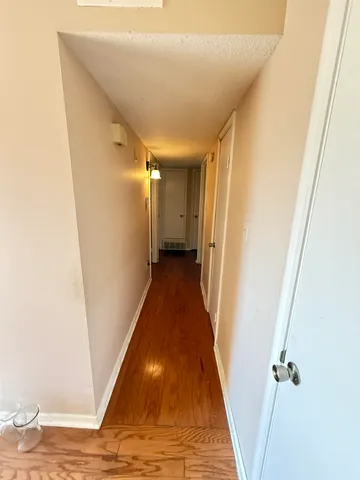 a view of a hallway with wooden floor and staircase