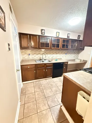 a large kitchen with stainless steel appliances kitchen island granite countertop a sink and cabinets