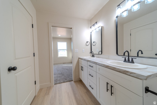 130 Pole Line Road, Unit 2 Roosevelt, UT 84066 - Photo 15 of 33 Dual vanity featuring white cabinetry, dark hardware, integrated sinks, and individual framed mirrors with overhead lighting