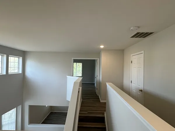 a view of a hallway with entryway and stairs