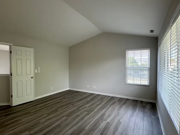 an empty room with wooden floor and window