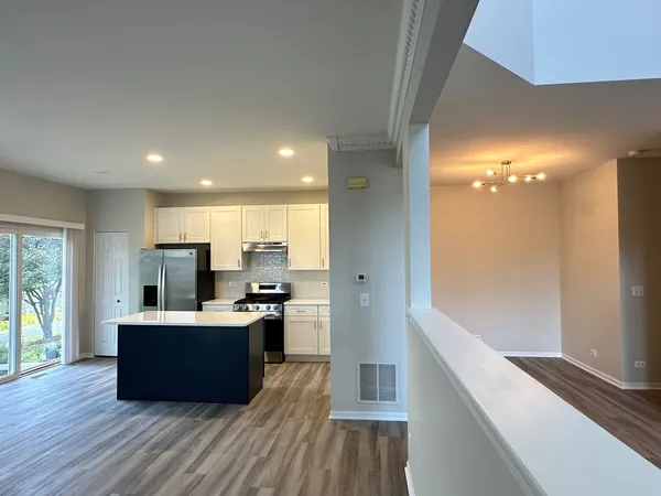 a living room with stainless steel appliances kitchen island wooden floor and view living room