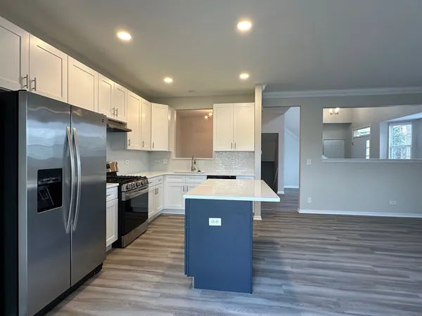 a kitchen with stainless steel appliances granite countertop a refrigerator a sink and a stove