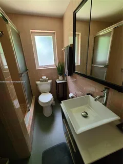 a bathroom with a sink toilet and mirror