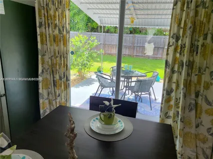 a dining room with furniture and a floor to ceiling window