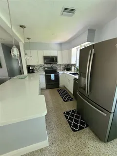 a kitchen with stainless steel appliances a refrigerator sink and stove