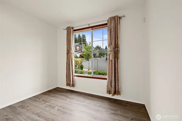 an empty room with wooden floor and a window