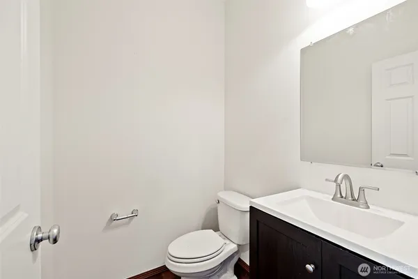 a bathroom with a granite countertop toilet sink mirror and vanity