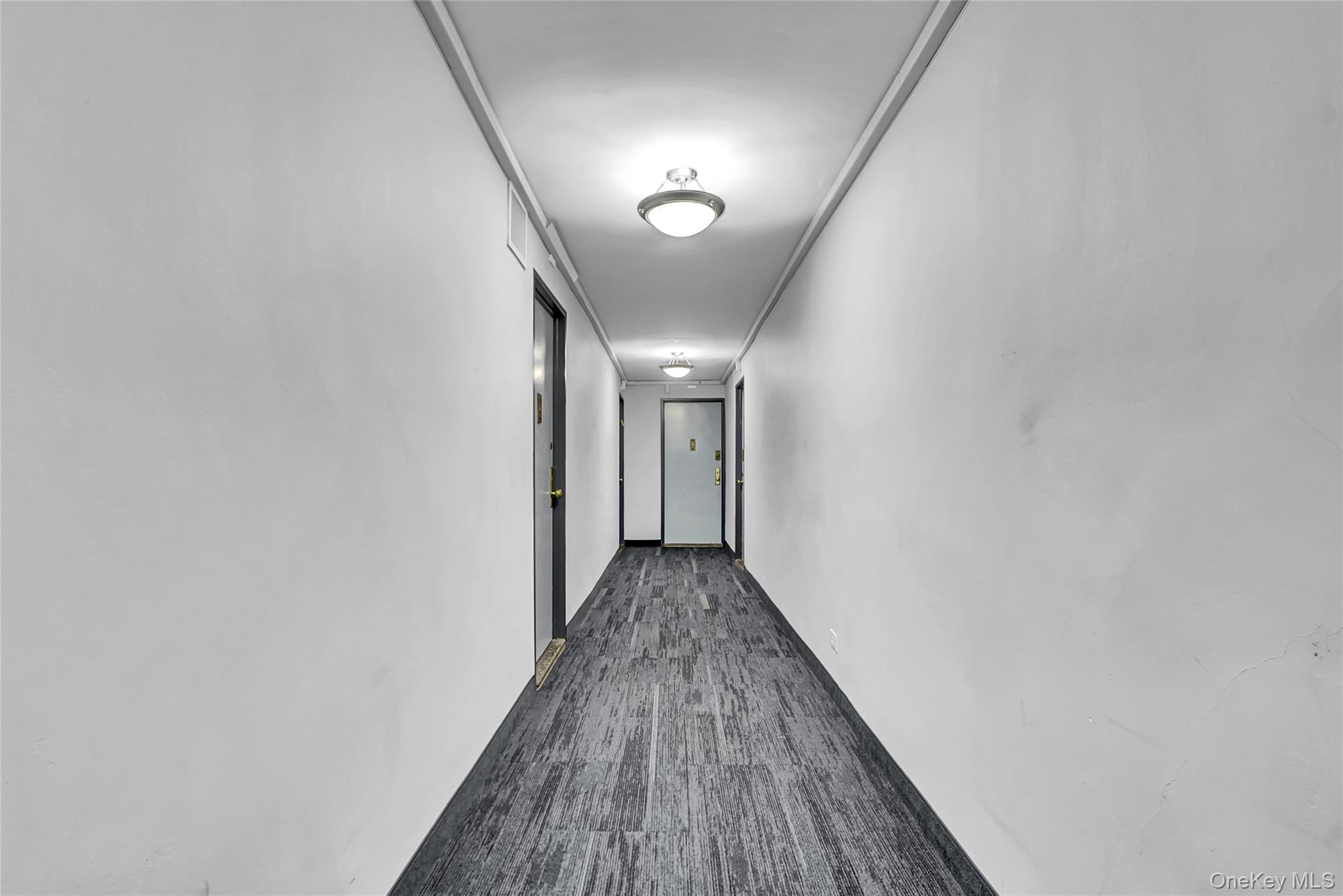 123-40 83rd Avenue, Unit 6D Queens, NY 11415 - Photo 13 of 14 Hallway with dark carpet and baseboards