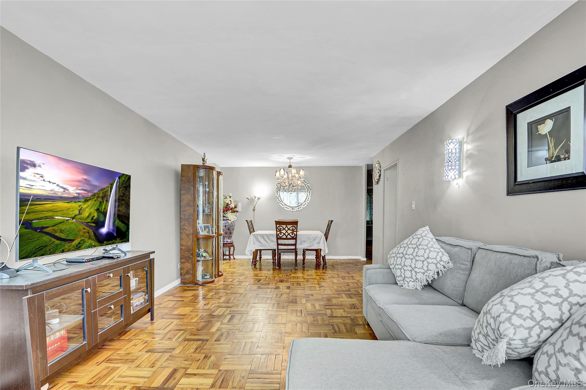 123-40 83rd Avenue, Unit 6D Queens, NY 11415 - Photo 7 of 14 Living area with a chandelier and baseboards