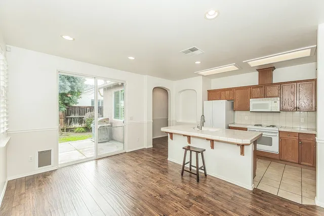 a large white kitchen with lots of counter space a sink and appliances