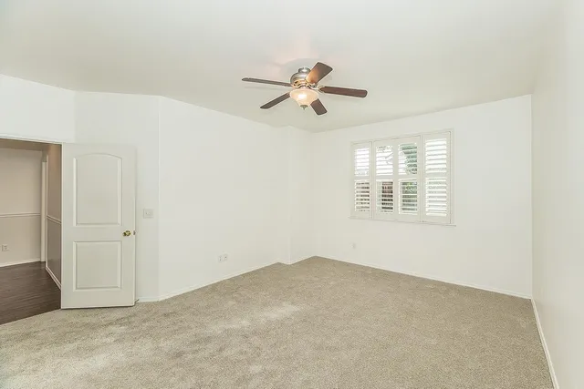 a view of a room with a ceiling fan and a window