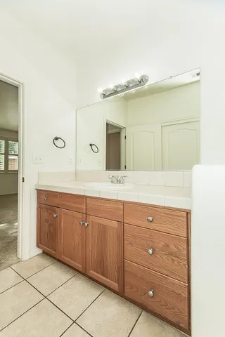 a spacious bathroom with a granite countertop sink and a mirror