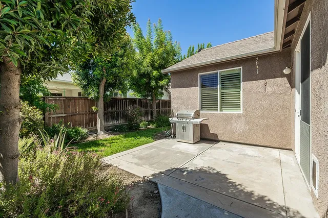 a view of a house with backyard and sitting area