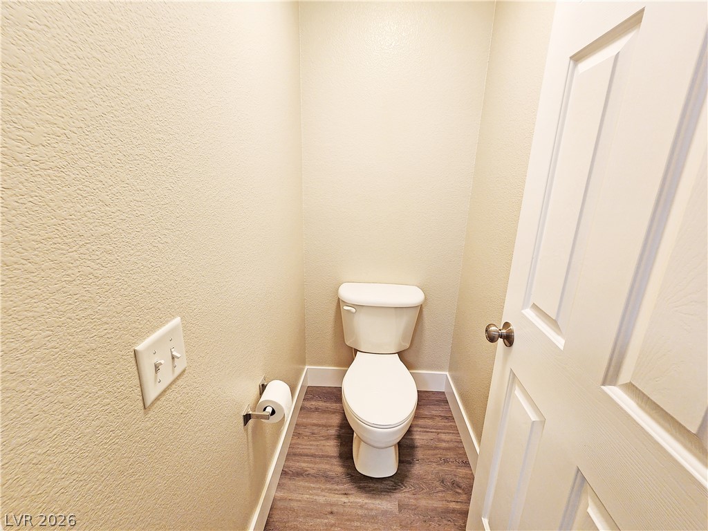 4591 Stoneham Street Pahrump, NV 89061 - Photo 21 of 42 A well-appointed lavatory offers essential comfort with wood-tone flooring and a classic toilet.
