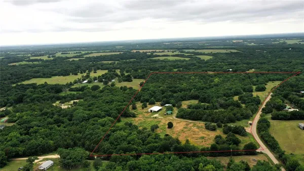 an aerial view of residential houses with outdoor space and trees