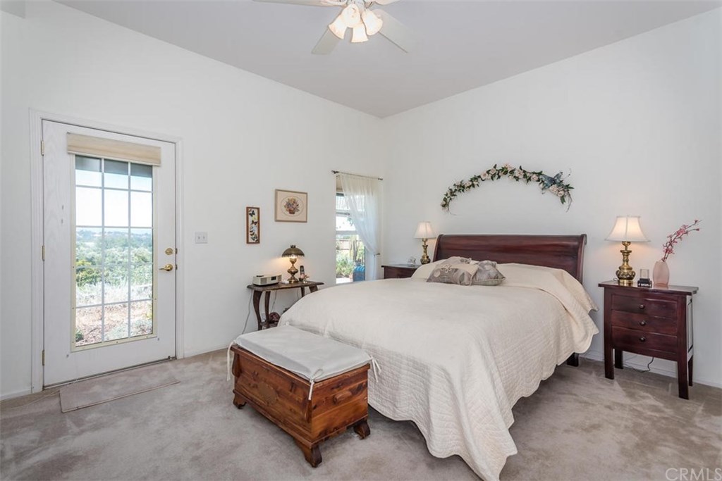 352 Quail Summit Paso Robles, CA 93446 - Photo 15 of 33 a spacious bedroom with a bed a chandelier and a window