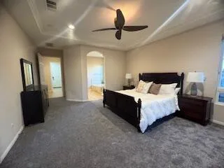 a spacious bedroom with a bed and a chandelier