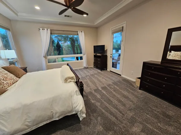 a spacious bedroom with a bed and a dresser