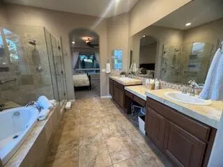 a large bathroom with a granite countertop double vanity sink a mirror and a shower