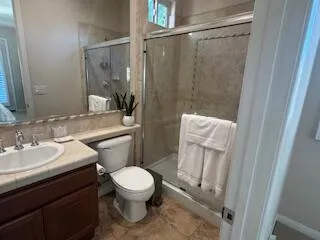 a bathroom with a sink a toilet a mirror and shower