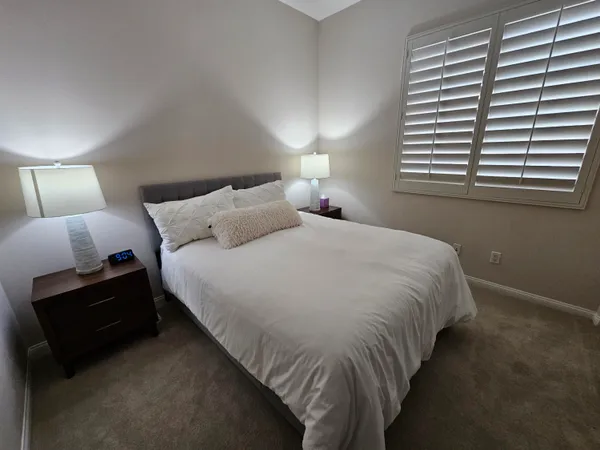 a bedroom with a bed and a lamp with window