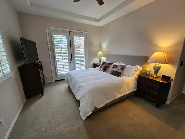 a bedroom with a bed flat screen tv and window
