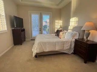a bedroom with a bed dresser and a flat tv screen