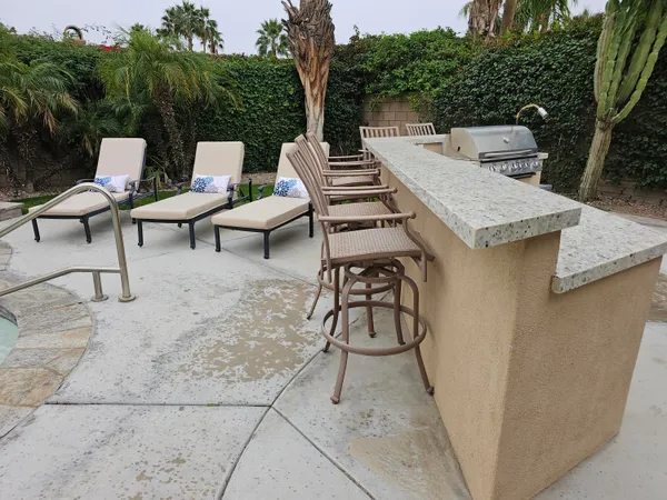 a view of a patio with table and chairs with wooden floor and fence