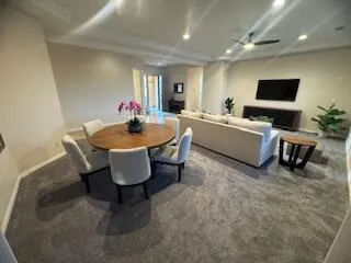 a living room with furniture a flat screen tv and kitchen view