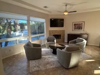 a living room with furniture a fireplace and a flat screen tv