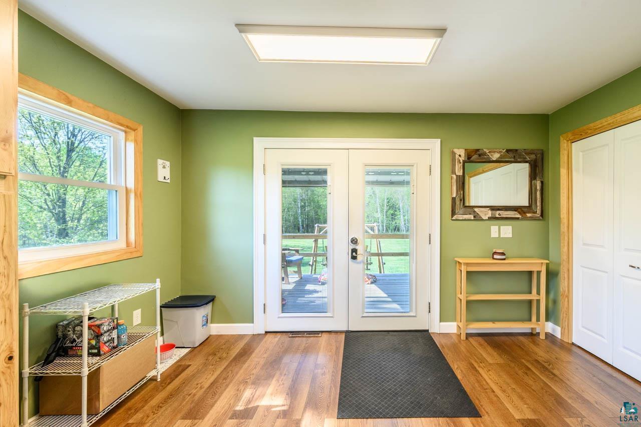 2581 O'Rourke Road Hibbing, MN 55746 - Photo 11 of 61 White double French doors with glass panels, wood-finish flooring, and a large window with natural wood trim