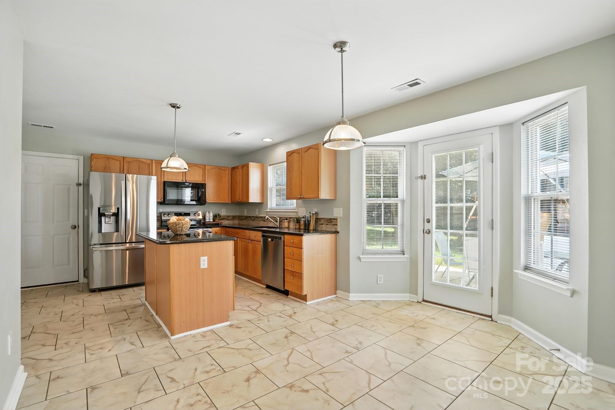 916 Knightsbridge Road Fort Mill, SC 29708 - Photo 4 of 41 a open kitchen with stainless steel appliances kitchen island granite countertop a refrigerator a oven and a sink