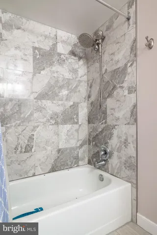 a bathroom with a tub sink and mirror